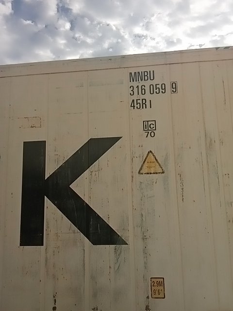 Container door at the QISW gate lane, its number framed for the camera to read